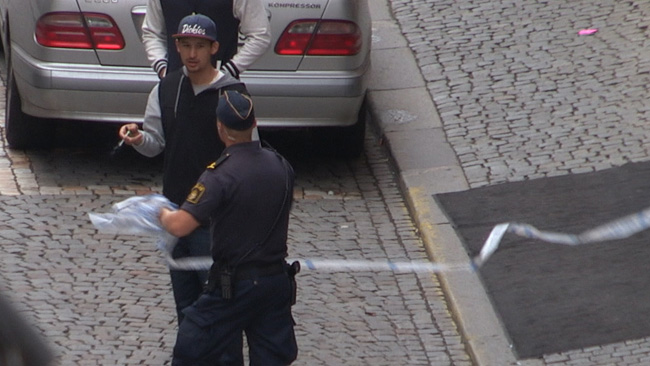 Här motar polisen bort en person som är nyfiken. Foto: Chang Frick / Nyheter Idag