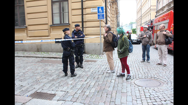 Nyfikna frågar polisen vad som händer. Foto: Amy Unsworth / Nyheter Idag