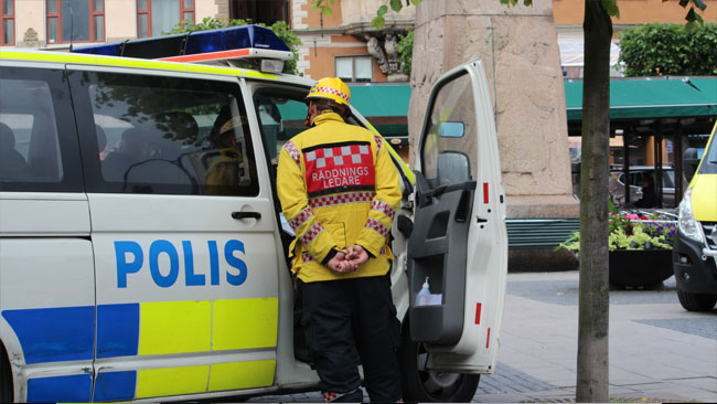 Räddningsledaren talar med polisen. Foto: Amy Unsworth / Nyheter Idag