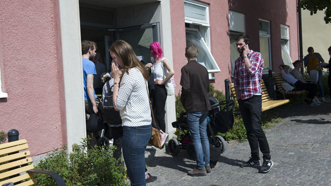 Här står några människor utanför lokalen där "Rummet" hade sitt arrangemang under Almedalsveckan. Foto: Sven Pernils / Nyheter Idag
