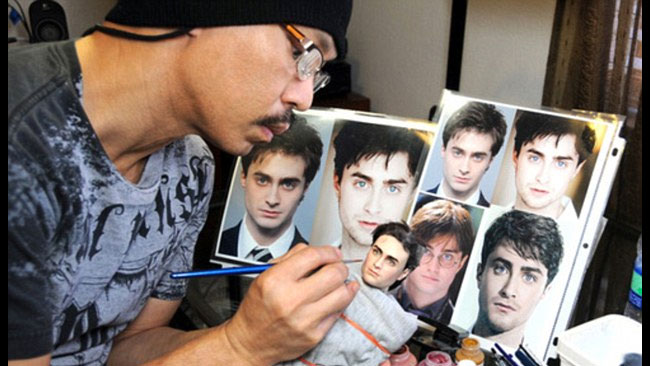 Noel Cruz koncentrerar sig när han målar om dockorna.