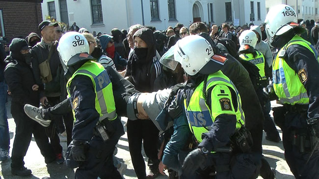 Motdemonstrant bärs iväg av polis. Foto: Fritz Schibli / TOPNEWS.se