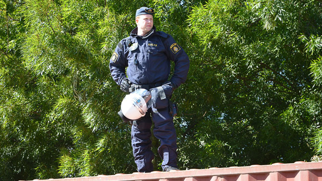 Här ser vi en polis stå på en container för att överblicka situationen. Foto: Fritz Schibli / TOPNEWS.se