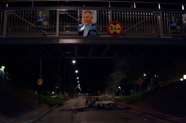 Nästan rakt under gångbron stod den utbrända bilen på tvären. Foto: Chang Frick / Nyheter Idag
