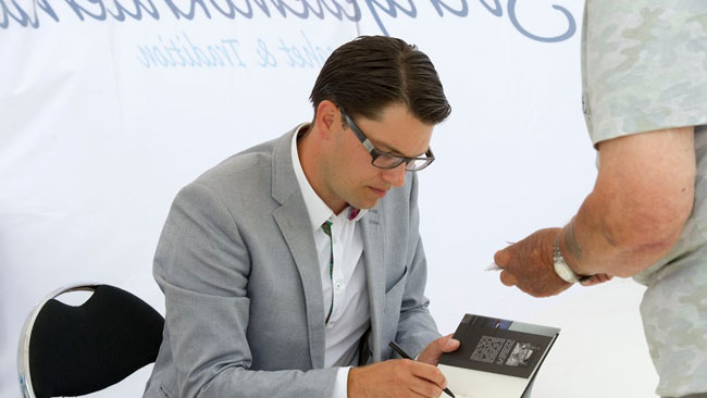 Här signerar Åkesson sin bok efter talet. Foto: Sven Pernils / Nyheter Idag