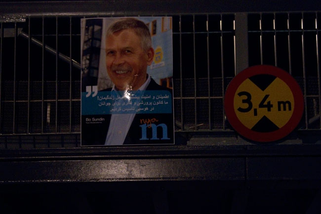 Bakom valaffischen på gångbron plockade polisen upp flera stenar. Foto: Chang Frick / Nyheter Idag