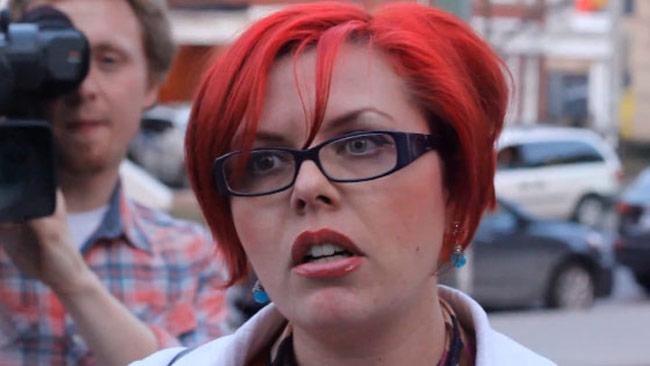 Arg feminist försöker stoppa ett möte hon inte tycker om. Foto: halloftheblackdragon.com