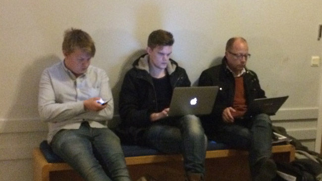 Här sitter tre journalister på en bänk utanför möteslokalen i Alvik. Foto: Sven Pernils