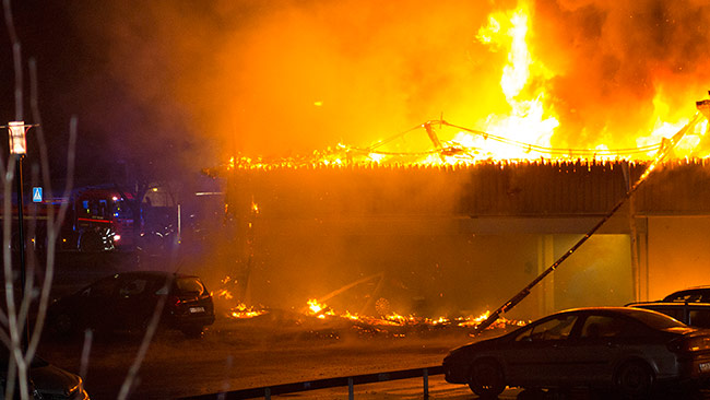 Här brinner ett helt parkeringsgarage ned till grunden. Foto: Chang Frick / Nyheter Idag