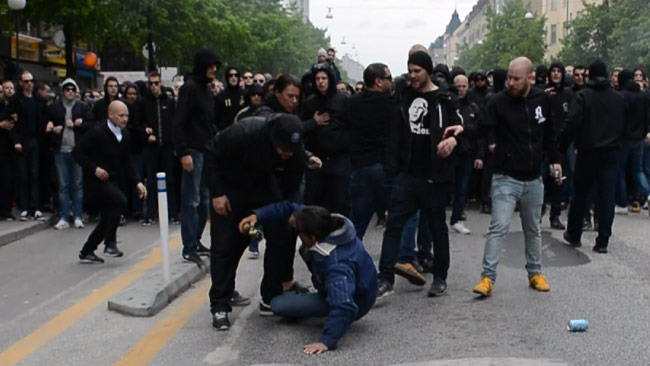 En man låg ner och fick ta emot sparkar från supportrarna. Foto: Nyheter Idag