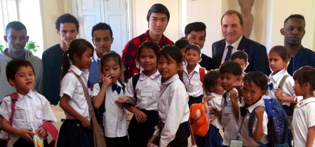 Vilka barn ska Löfven satsa på? Statsminister Stefan Löfven tillsammans med ensamkommande flyktingbarn i bakgrunden. Kambodjanska barn, som svenska Sida hjälper med skolgång, i förgrunden. Foto: Regeringen/Sida