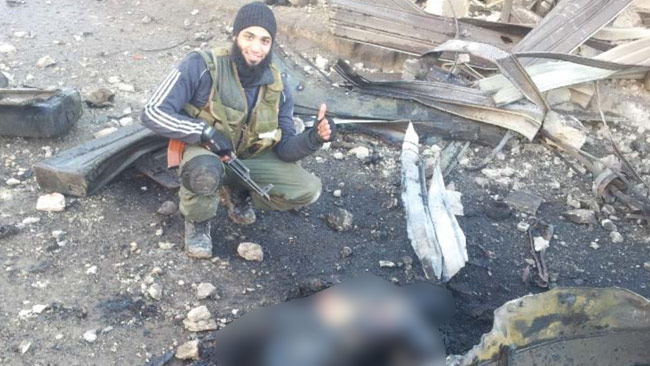 Hassan Mostafa Al-Mandlawi framför liket av en sönderbränd människa. Foto: Polisen