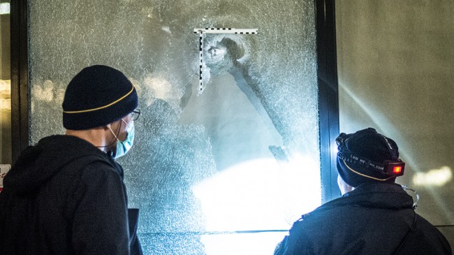 Polisens tekniker undersökte vad som ser ut att vara ett kulhål i ett skyltfönster på Vantörsvägen. Foto: Nyheter Idag