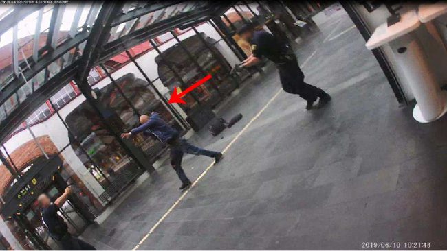 Misstänkt går mot poliserna med höjda händer.